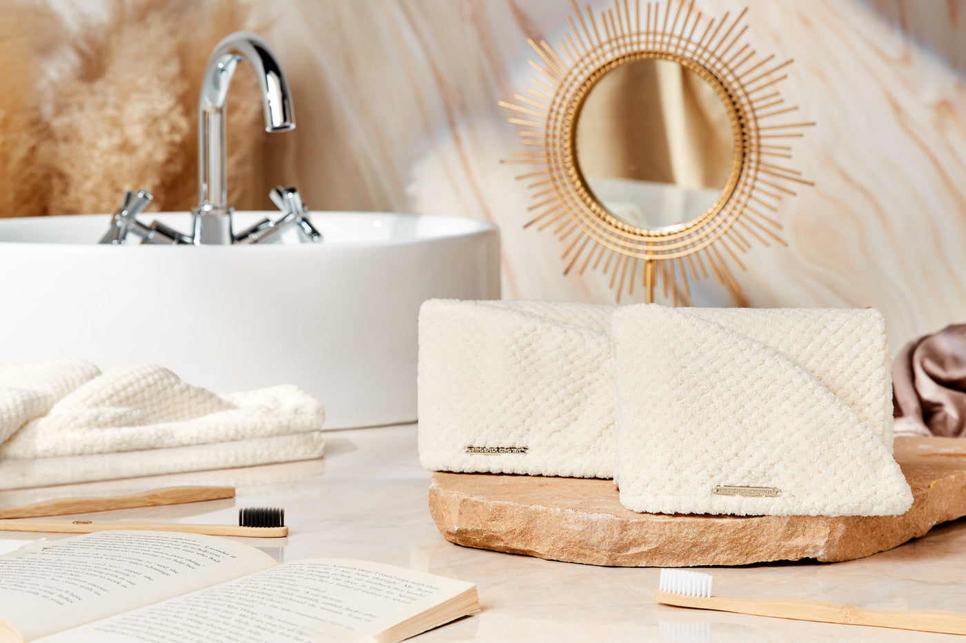 Two Phoenix Crown Cuticle Armour Towels displayed against a bright, luxurious bathroom scene